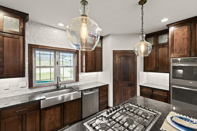 kitchen featuring a sink, decorative backsplash, dark brown cabinetry, and appliances with stainless steel finishes