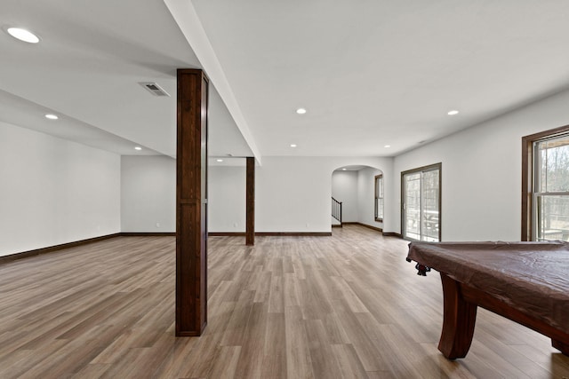 game room with light wood-style flooring, recessed lighting, arched walkways, and baseboards