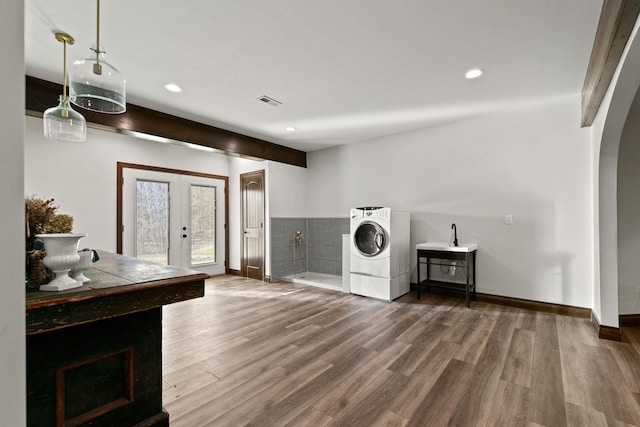 laundry room with laundry area, recessed lighting, french doors, wood finished floors, and arched walkways