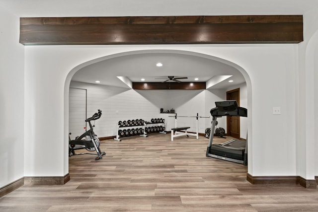 exercise area with a ceiling fan, wood finished floors, baseboards, recessed lighting, and arched walkways