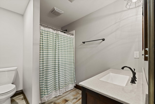 bathroom featuring visible vents, toilet, a shower with shower curtain, wood finished floors, and vanity