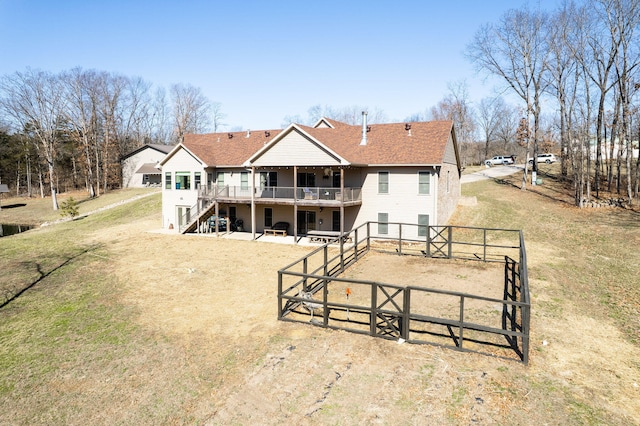 back of property featuring a deck, stairway, fence, and a shingled roof