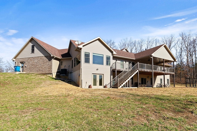 rear view of property featuring stairway, central AC, french doors, a deck, and a lawn