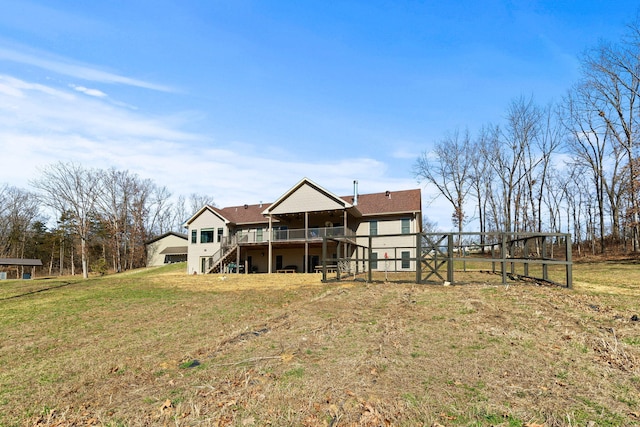 rear view of house with a wooden deck, a lawn, and stairs