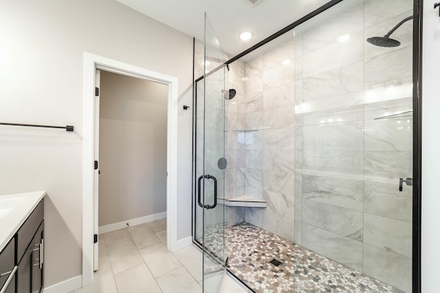 bathroom featuring a stall shower, tile patterned flooring, vanity, and baseboards