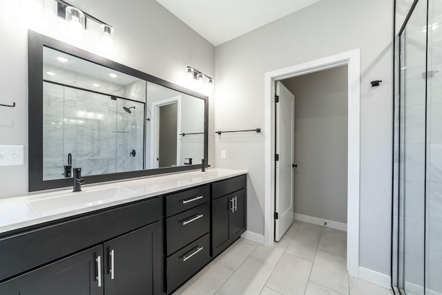 bathroom featuring baseboards, double vanity, a sink, and a shower stall