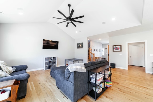 living room with light wood-style flooring, visible vents, baseboards, vaulted ceiling, and a ceiling fan