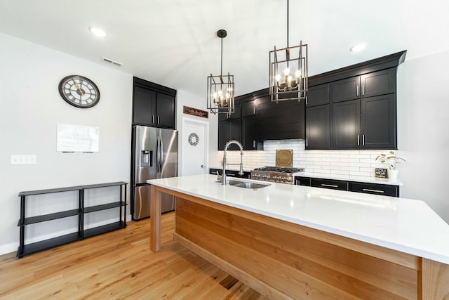 kitchen with stainless steel refrigerator with ice dispenser, light countertops, visible vents, backsplash, and a sink