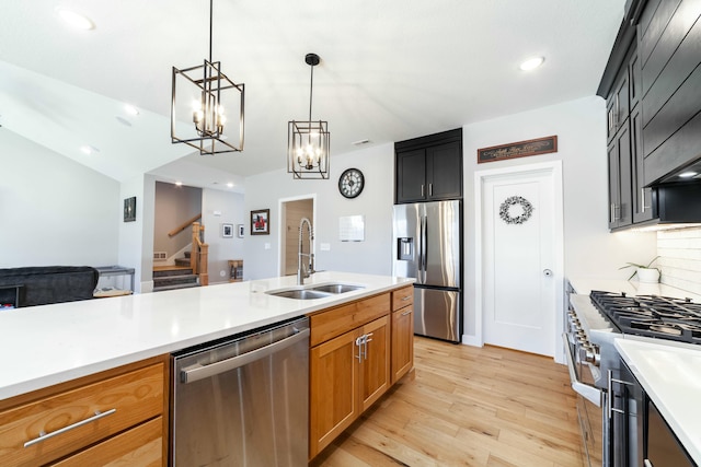 kitchen featuring light countertops, appliances with stainless steel finishes, light wood-type flooring, and a sink