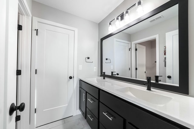 full bath featuring double vanity, visible vents, and a sink