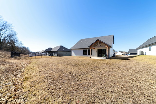 rear view of house with a patio, a yard, and fence