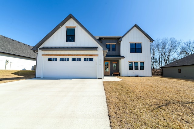 modern farmhouse with concrete driveway, board and batten siding, a standing seam roof, metal roof, and a front lawn