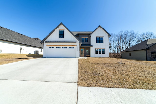 modern farmhouse style home featuring board and batten siding, a standing seam roof, metal roof, a garage, and driveway