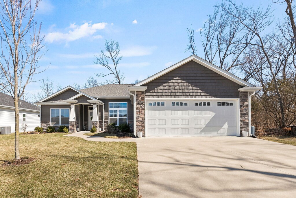 7590 S Lavender Dr, Columbia, MO 65203 - craftsman house with stone siding, driveway, an attached garage, and a front lawn