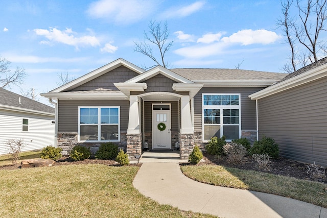 view of front of home with stone siding and a front lawn