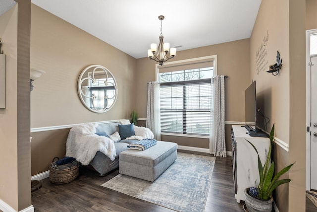 living area with vaulted ceiling, a notable chandelier, wood finished floors, and baseboards