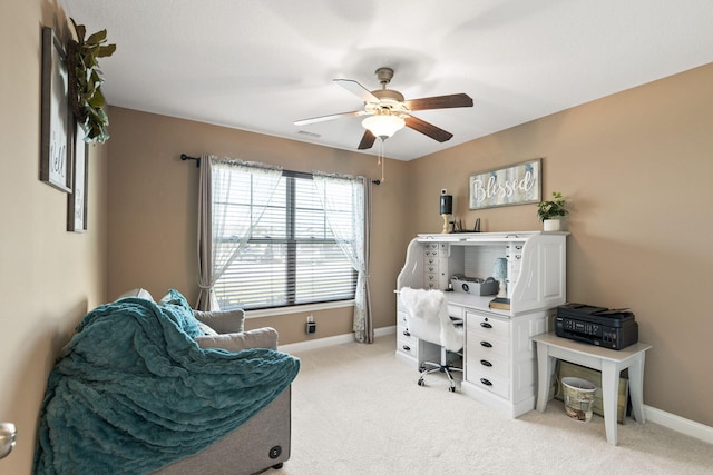 home office with light carpet, visible vents, a ceiling fan, and baseboards