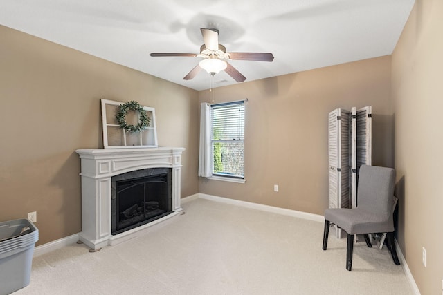 living area featuring baseboards, carpet floors, a ceiling fan, and a fireplace