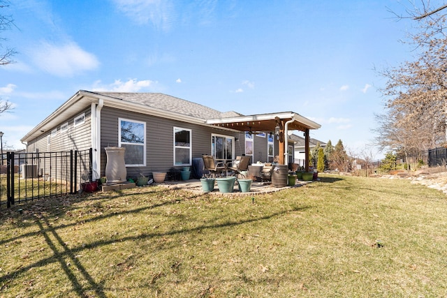 rear view of property featuring a patio area, a lawn, fence, and a shingled roof