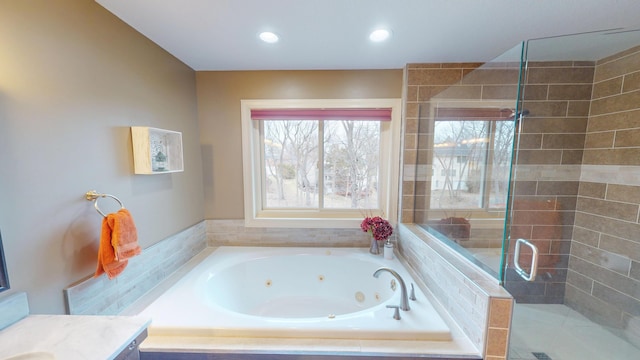 bathroom with a tub with jets, a shower stall, and recessed lighting