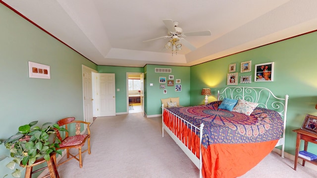 bedroom featuring a tray ceiling, visible vents, carpet flooring, ceiling fan, and baseboards