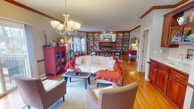 living room with light wood-style flooring, a fireplace, ornamental molding, and baseboards