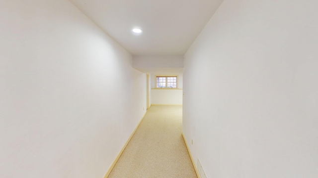 corridor featuring recessed lighting, light colored carpet, and baseboards