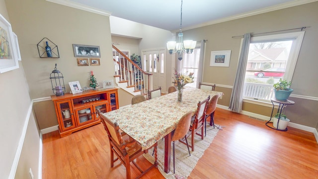 dining area featuring a chandelier, crown molding, stairway, and light wood finished floors