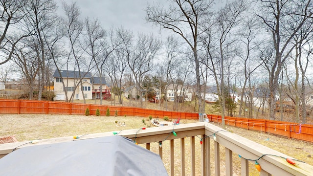 wooden terrace with a residential view and a fenced backyard