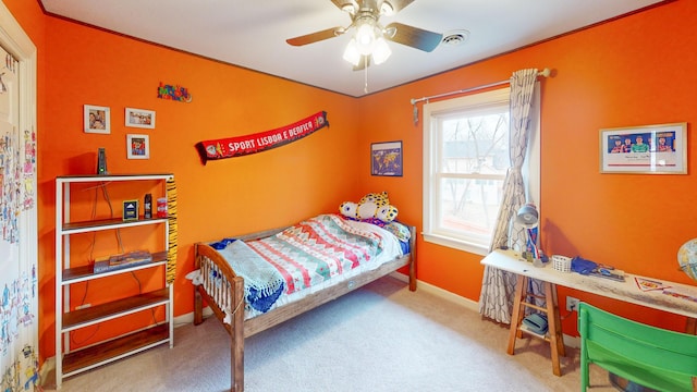 carpeted bedroom featuring a ceiling fan, visible vents, and baseboards