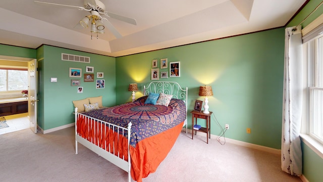 bedroom featuring a tray ceiling, carpet, visible vents, and baseboards