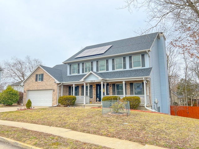 view of front facade with solar panels, a porch, a chimney, and brick siding