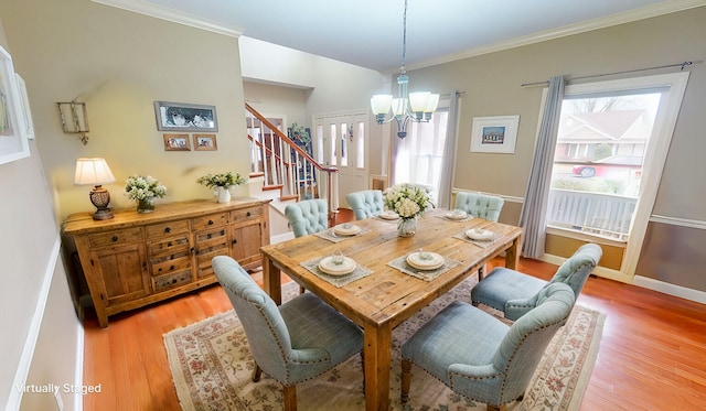 dining area with baseboards, ornamental molding, stairway, light wood-type flooring, and an inviting chandelier