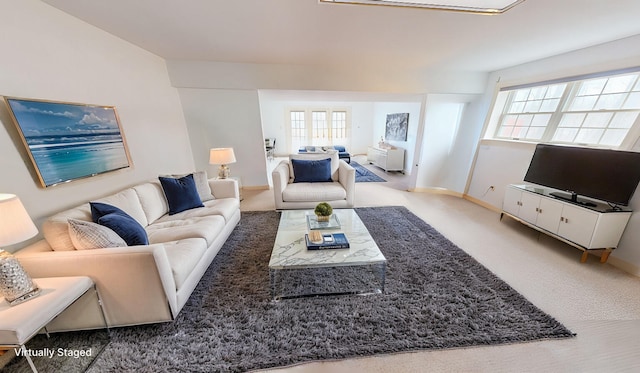 living area featuring carpet flooring and baseboards