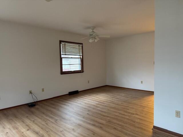 unfurnished room with ceiling fan, baseboards, and wood finished floors