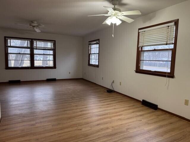 spare room featuring light wood-style flooring, baseboards, and ceiling fan