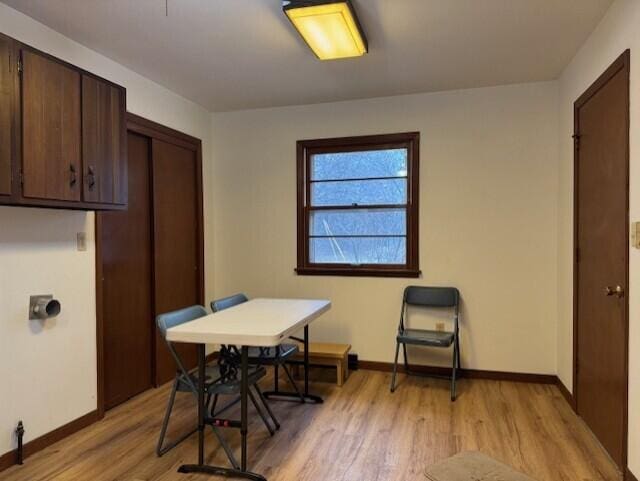 dining room featuring baseboards and light wood finished floors