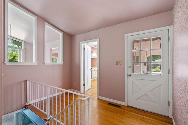 entryway with light wood-style flooring, visible vents, and baseboards