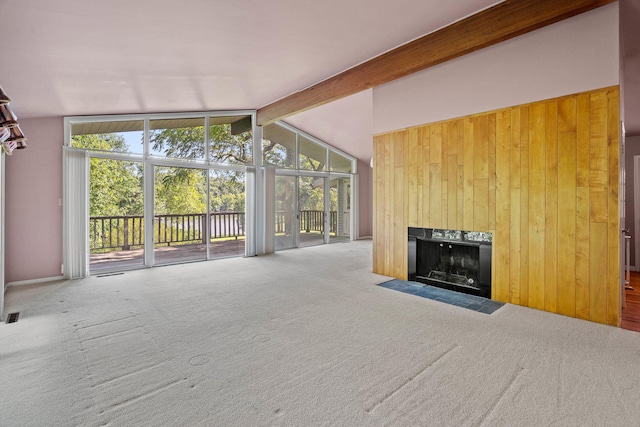 unfurnished living room with carpet floors, a fireplace with flush hearth, and a healthy amount of sunlight