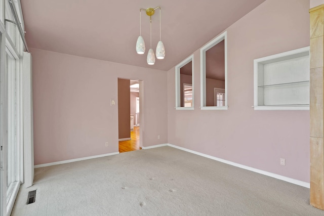 spare room featuring baseboards, visible vents, and carpet flooring