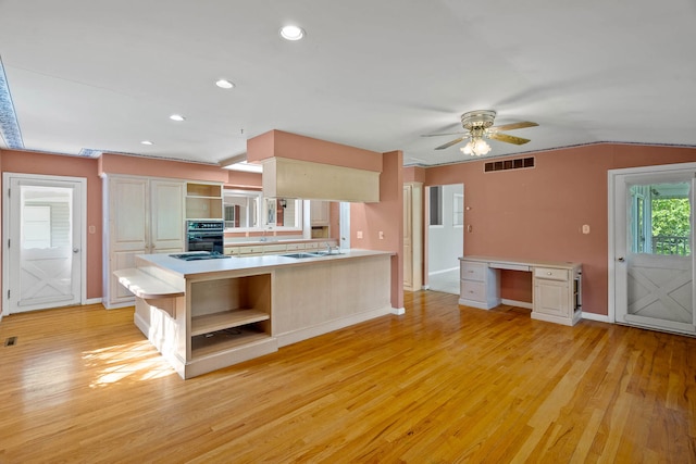 kitchen featuring a sink, visible vents, light wood-style floors, light countertops, and open shelves