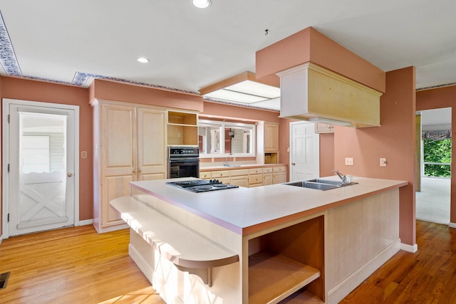 kitchen with stovetop with downdraft, light wood-type flooring, oven, and open shelves