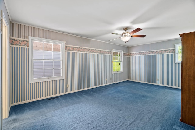 unfurnished room with carpet, crown molding, visible vents, ceiling fan, and baseboards