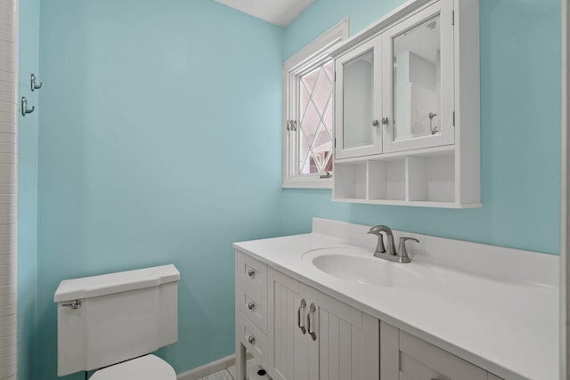 bathroom featuring toilet, baseboards, and vanity