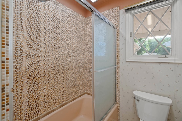 full bathroom featuring toilet and bath / shower combo with glass door