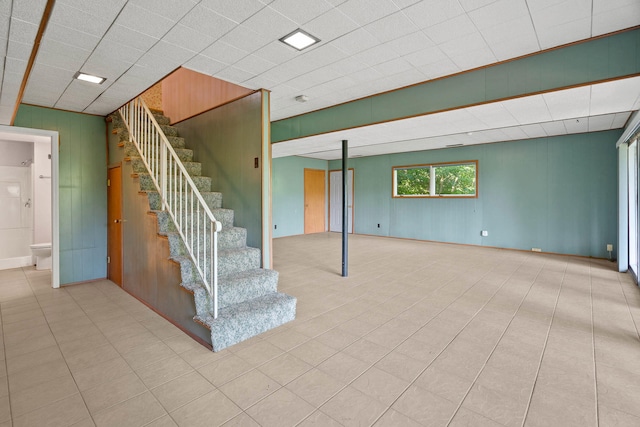 below grade area with tile patterned flooring and stairs