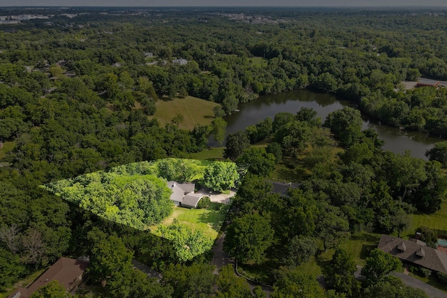 birds eye view of property featuring a water view and a view of trees