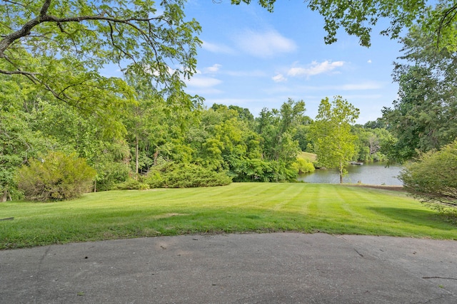 view of property's community with a lawn and a water view