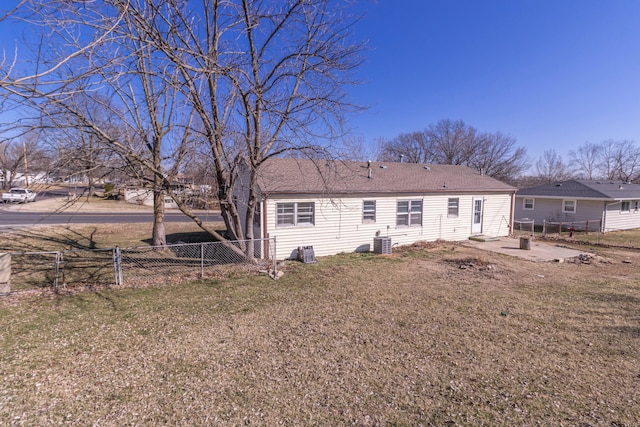 back of house with central AC unit, a patio area, a yard, and fence