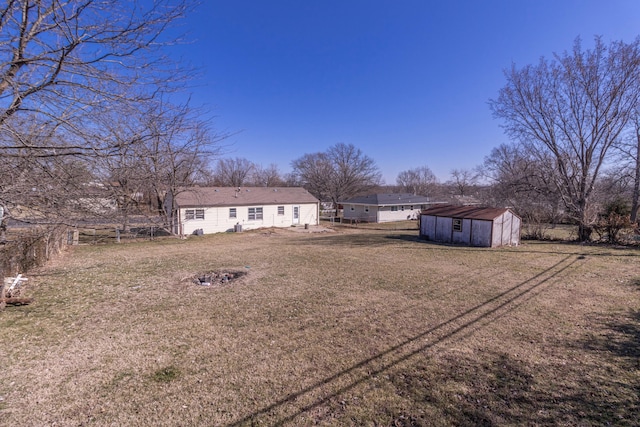 view of yard featuring a shed, an outdoor structure, and fence